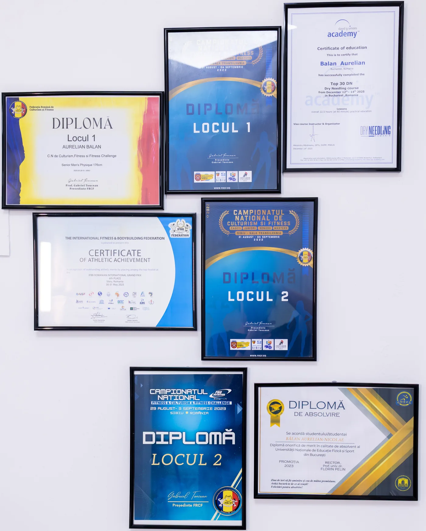 Diplomele lui Aurelian pe peretele cabinetului: Locul 1 și 2 la Campionatele Naționale FRCF, certificat IFBB, Dry Needling, diplomă UNEFS